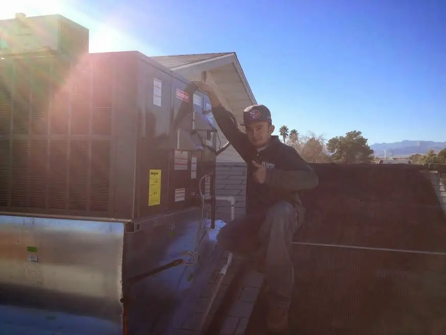 HVAC technician performing Boiler Repair on a rooftop unit in Olive Branch